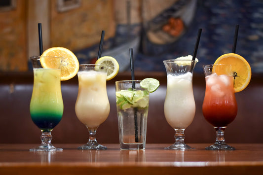 Summer coctails in the table. Piña Colada with pineapple slice, Blue lagoon, mojito with lime and mint, creamy coctail, tequila sunrise with orange