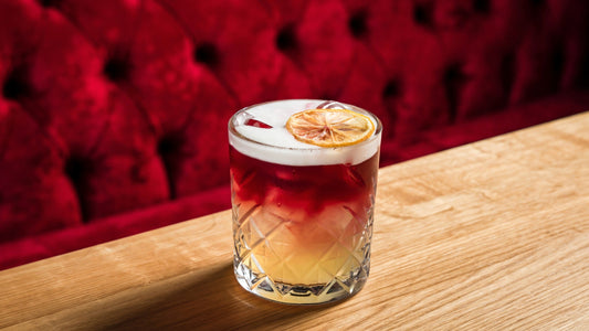 New York sour or Continental sour cocktail with bourbon or whisky garnished with dried lemon wheel at the wooden table at bar or restaurant