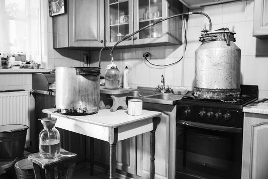 Old-fashioned moonshine machine for creating homemade strong alcohol in the kitchen. Process of distillation, general view.
